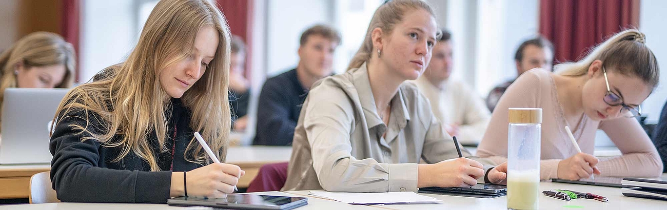 Das Bild zeigt Studierende in einer Vorlesungssituation