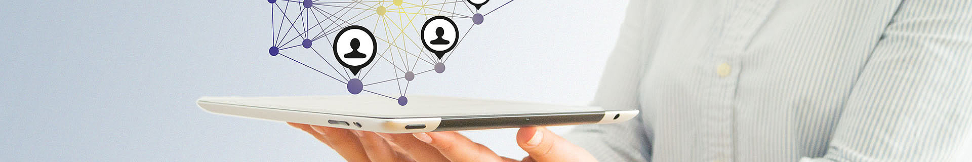 Das Bild zeigt eine Person, die mit einer Hand ein Tablet hält. Über dem Tablet ist eine digitale Netzwerkdarstellung zu sehen – mit miteinander verbundenen Knotenpunkten und Linien. Einige dieser Knoten enthalten Symbole von Personen, was auf soziale Netzwerke oder digitale Verbindungen hinweist. Der Hintergrund ist schlicht und hell, und die Person trägt ein helles Hemd mit vertikalen Streifen.