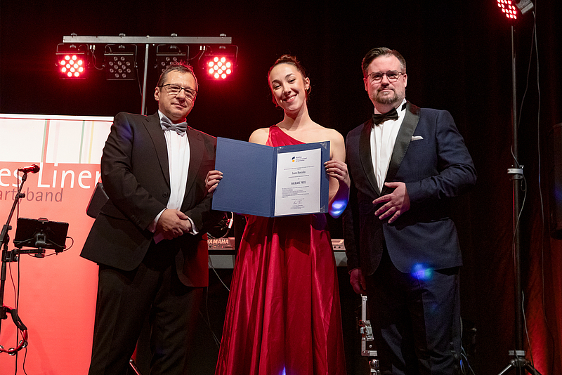 Preisträgerin mit Urkunde und Übergebenden