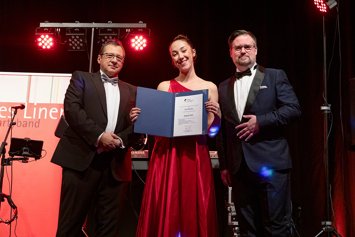 Preisträgerin mit Urkunde und Übergebenden