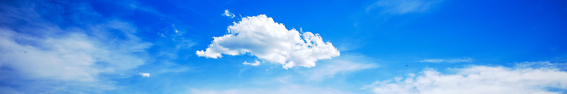 Das Bild zeigt einen leuchtend blauen Himmel mit einigen verstreuten weißen Wolken. Die größte Wolke befindet sich zentral im Bild, während kleinere Wolkenfetzen drumherum sichtbar sind. Es handelt sich um eine ruhige, klare Wetteraufnahme ohne weitere Objekte oder Text.