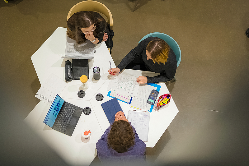 Drei Studierende am Tisch, Perspektive von oben