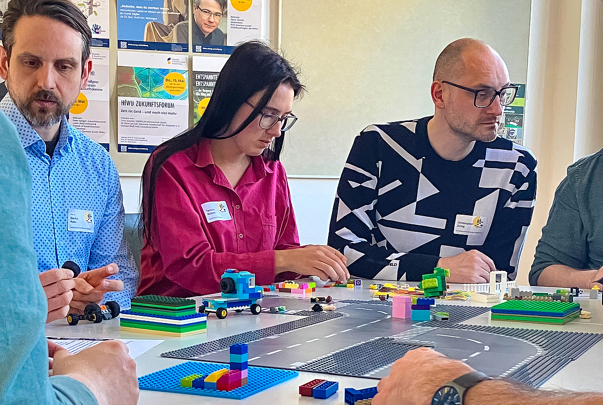 Personen am Tisch mit Legosteinen