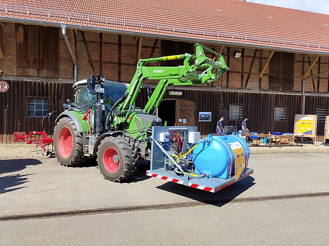 Traktor mit Wassertank auf Hebebühne vorne, rechte Seitenansicht