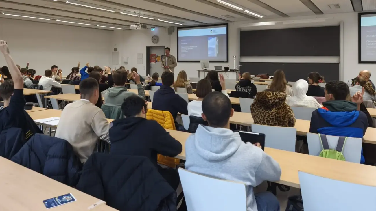 Blick von hinten in einen Hörsaal, voll besetzt mit Schüler:innen.